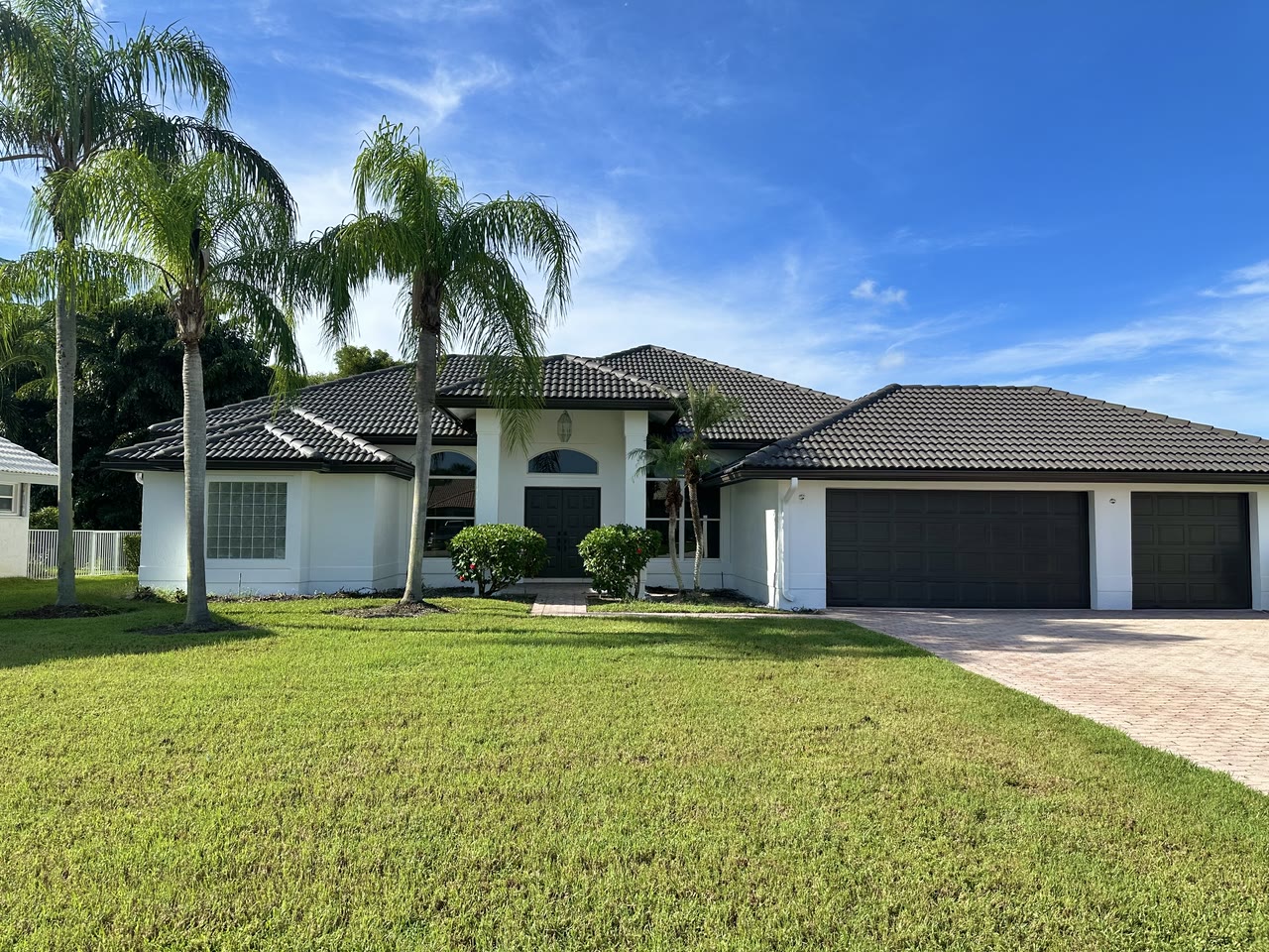 The completed exterior with crisp white stucco and charcoal architectural details.